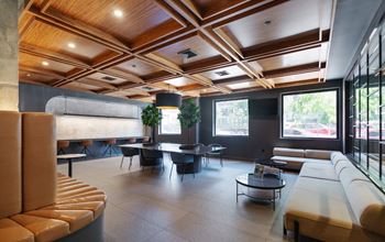 a lobby with couches tables and chairs and a coffered ceiling